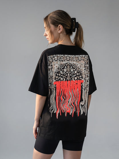 Person wearing a black t-shirt with a "MONARCH" design on the back against a gray background