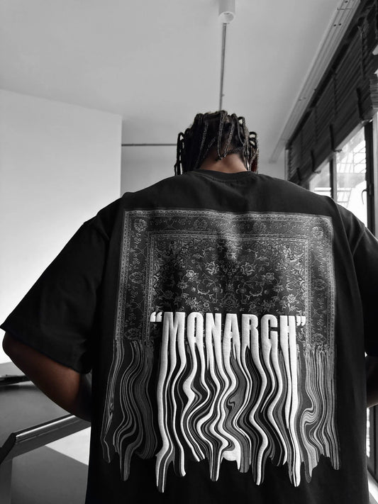Person wearing a black t-shirt with 'MONARCH' design on the back in an indoor setting.