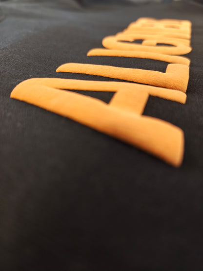 A close-up shot of a black fabric surface featuring large, raised orange letters spelling out 'ALIGN' diagonally.